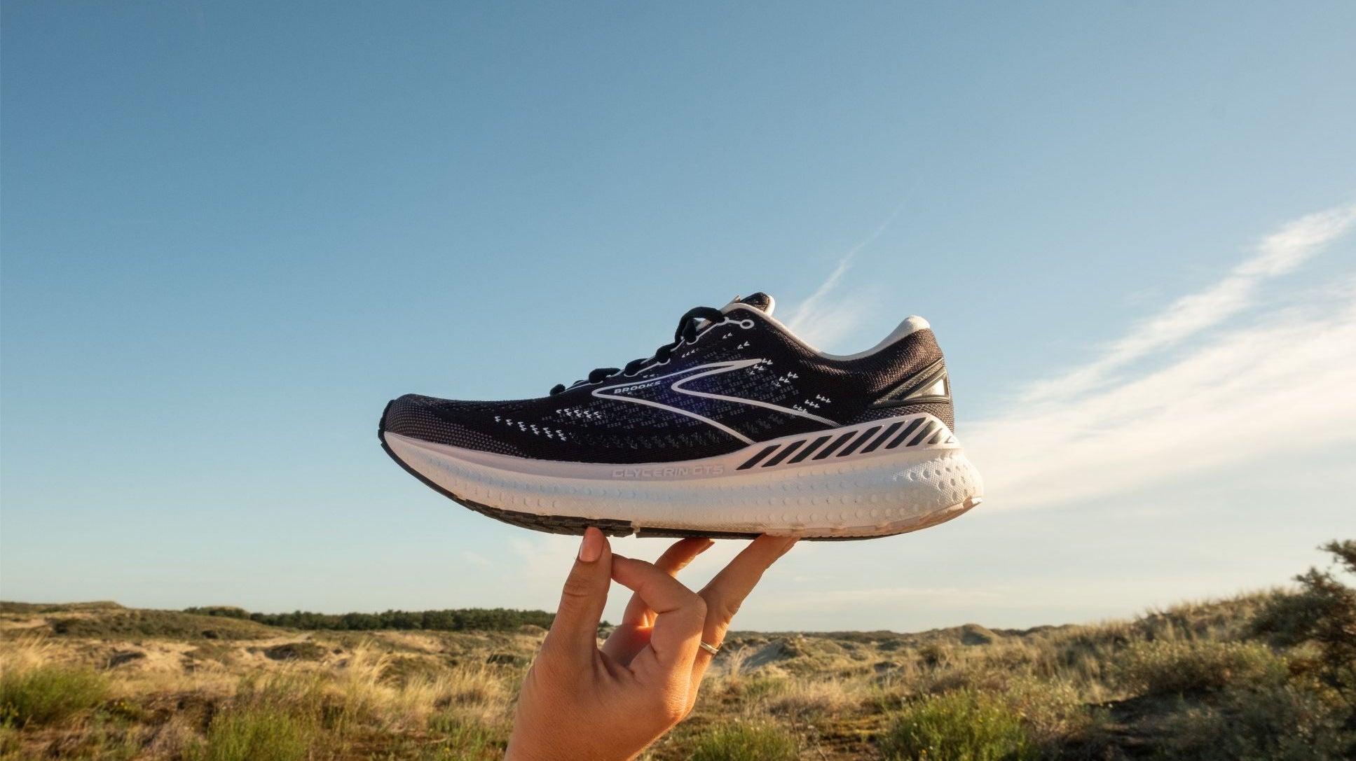 Ein Laufschuh von Brooks wird in die Höhe gehoben.