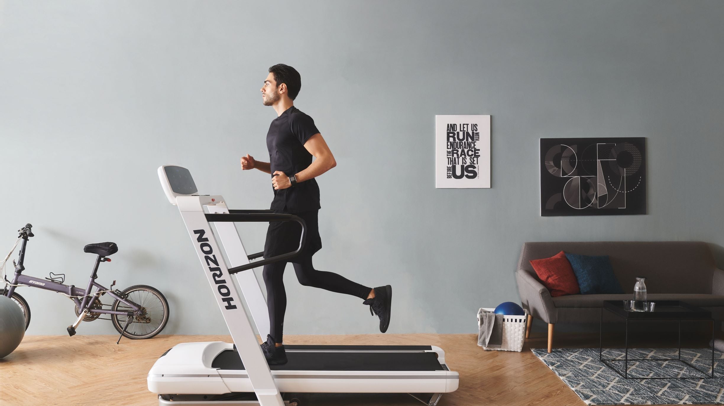 Mann läuft in seinem Wohnzimmer auf einem Laufband.