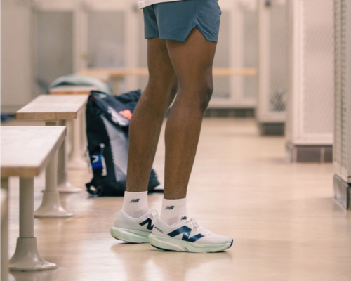 Eine Person steht in der Umkleide mit New Balance Schuhen.