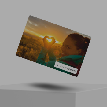 Ein Sport Kuhn Gutschein schwebt im Bild über einem weißen Würfel.