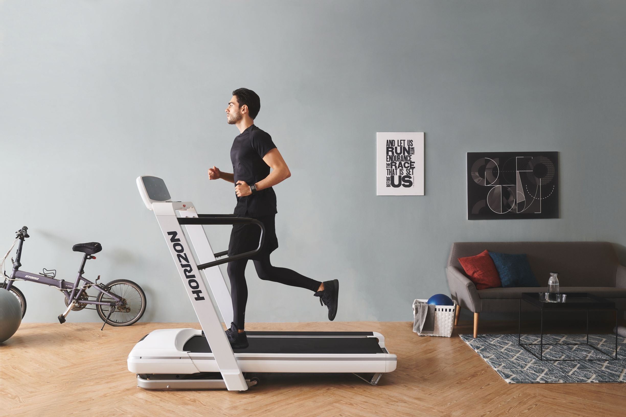 Mann läuft in seinem Wohnzimmer auf einem Laufband.