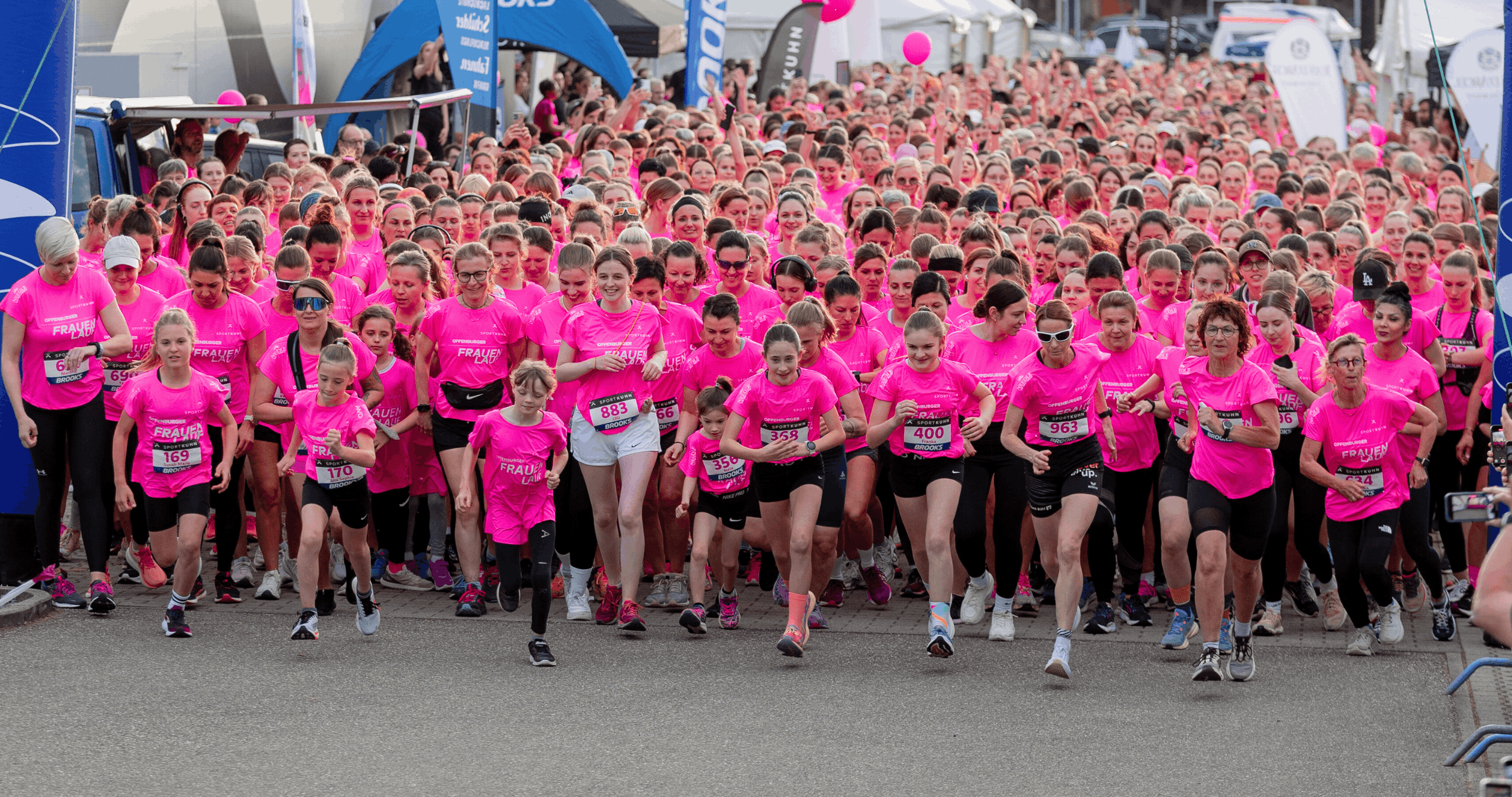 Viele Frauen laufen in pinken T-Shirts los.