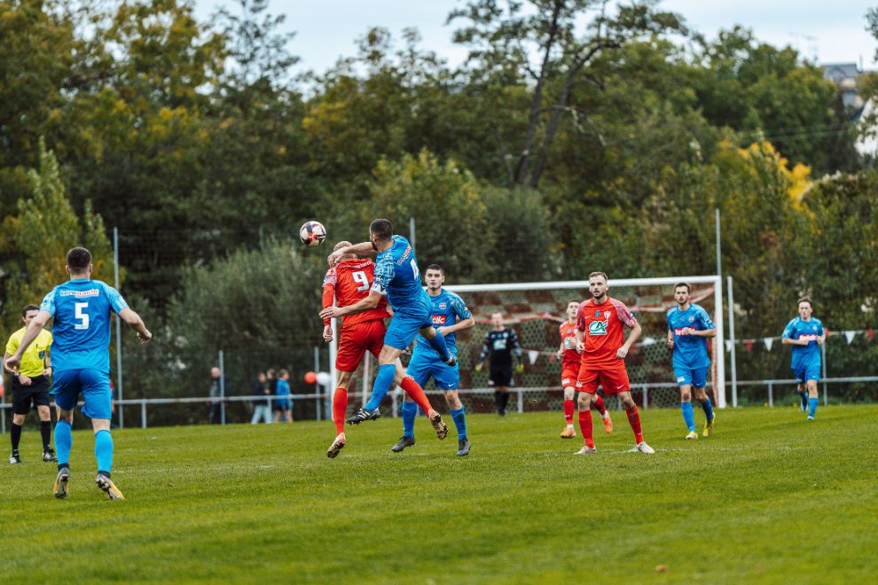 Fußballspiele von einer Mannschaft in roten und einer Mannschaft in blauen Trikots.