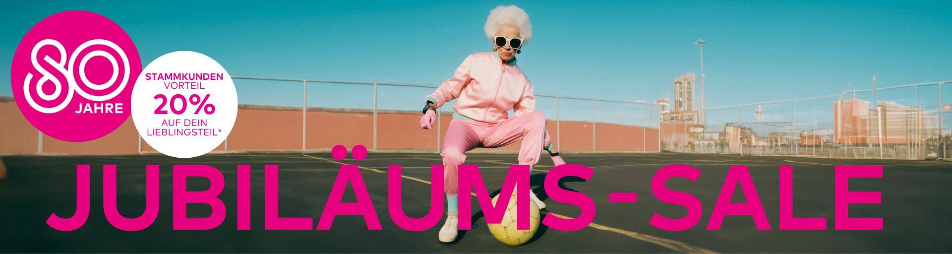 Ältere Dame spielt in einem rosafarbenen Jogginganzug mit einem Fußball auf einem Straßenfußballplatz.