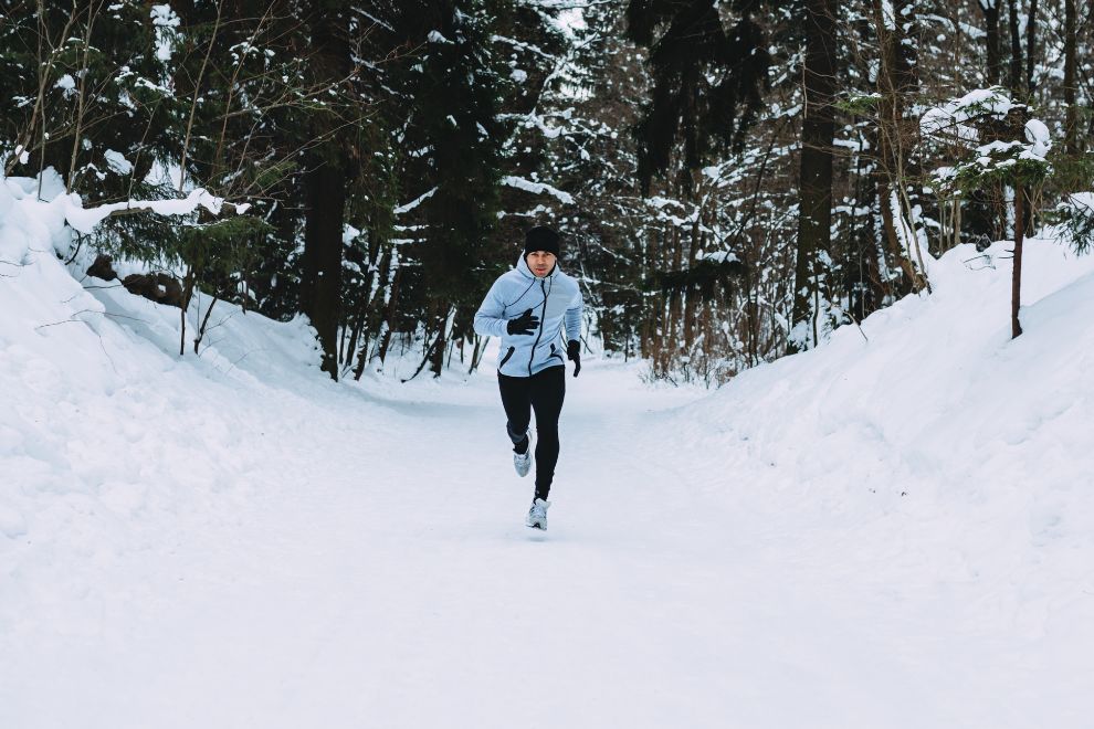 Läufer joggt im Wald im Schnee.